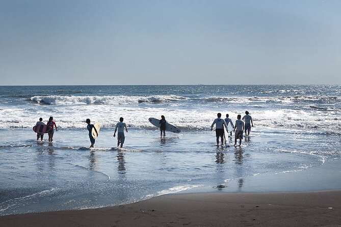Personas con tabla de surf en la playa de Monterrico